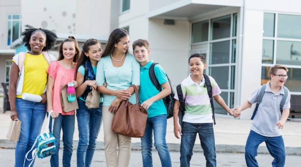 istock Teacher and students outdoors, boy with down syndrome 1264589073