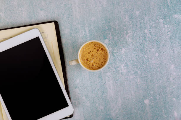 istock Workplace top view coffee cup and weekly planner for business with to do list on digital tablet 1264593684