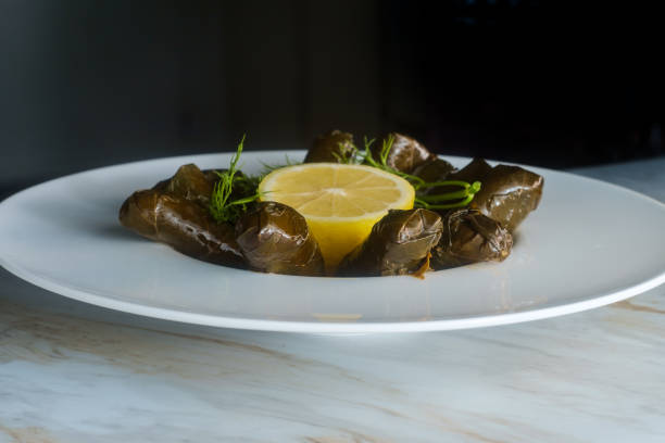 Armenian yaprak dolma, stuffed grape leaves garnished with lemon and fresh dill