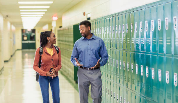 istock Teacher and high school student walking in hallway 1264595532