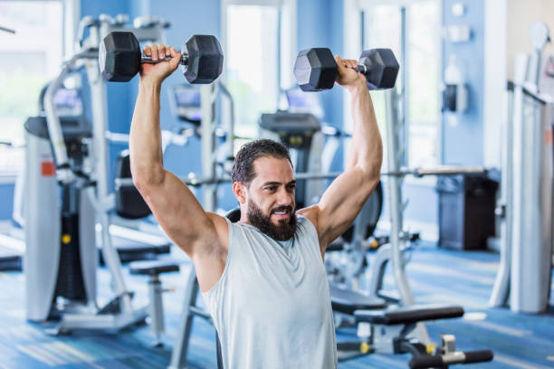 istock Middle Eastern man exercising at the gym lifting weights 1264596120