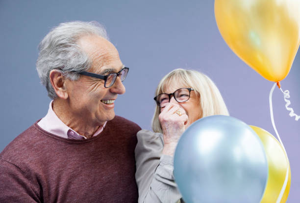 istock Happy senior couple with balloons 1264598961