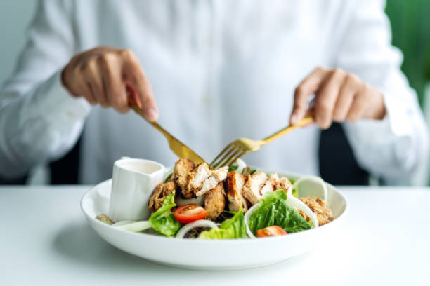 istock a woman eating chicken salad on table in the restaurant 1264603720