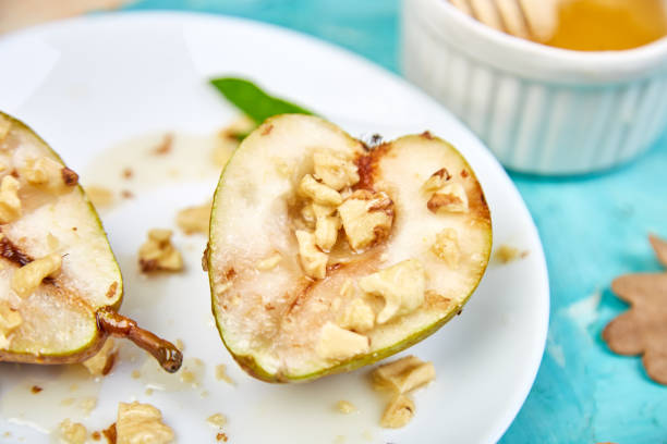 istock Tasty roast pears with honey and walnuts on blue background table. 1264606346