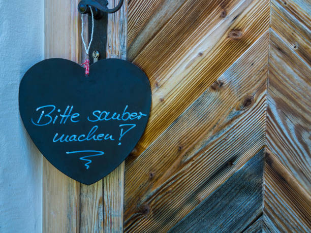 istock Please make up room. Black wooden board in heart shape. German language 1264608142