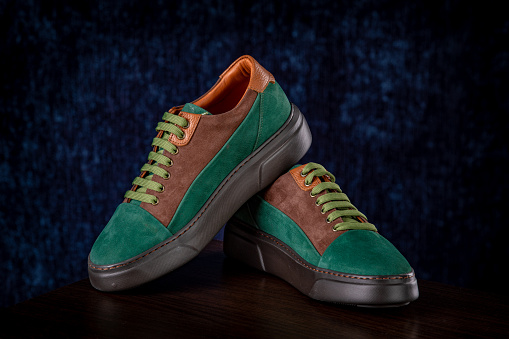 Men's modern green suede shoes on blue background