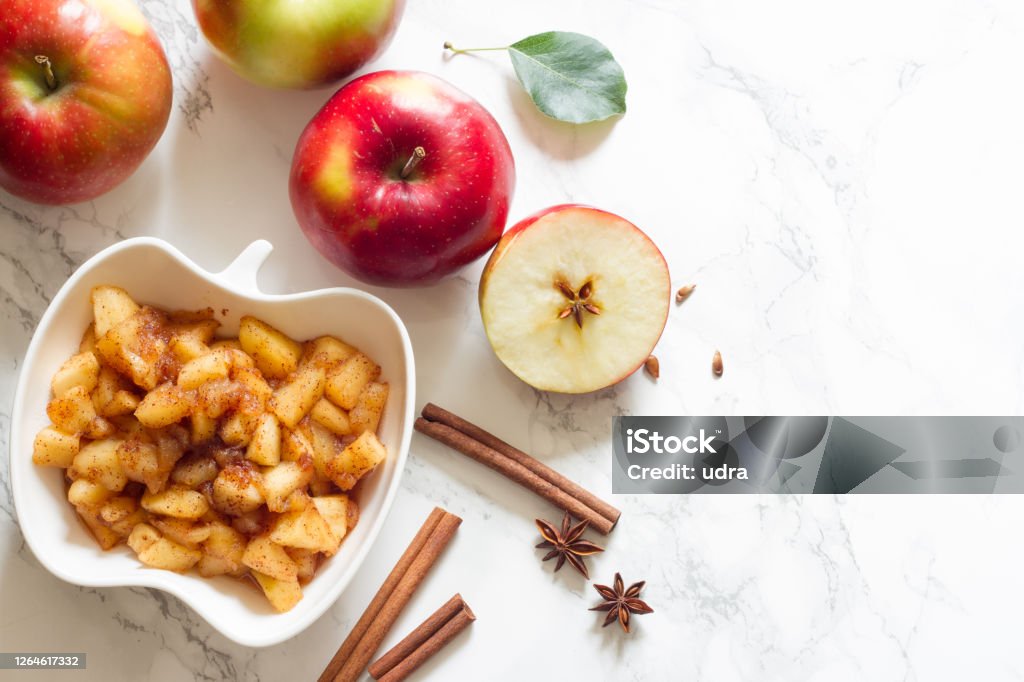 Apples, cinnamon and chunky applesauce on white background Apples, cinnamon and chunky applesauce on white background concept Apple - Fruit Stock Photo