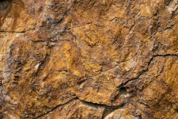 Granite rock surface. Brown natural granite with cracks.