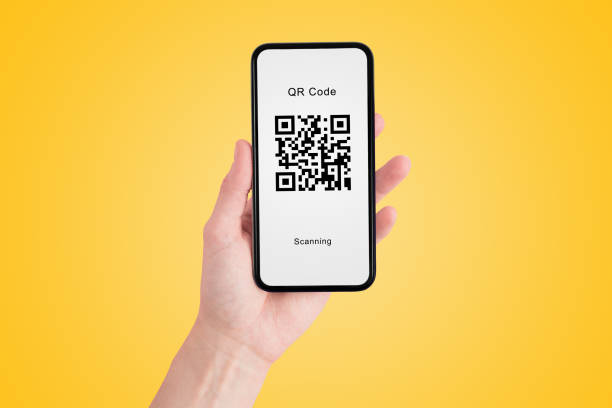 istock Hand holding smartphone that showing sample of quick response code icon symbol on white screen in yellow background. 1264622007