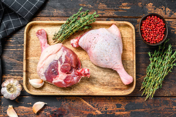istock Duck  legs on cutting board, Raw meat. Dark background. Top view 1264627276