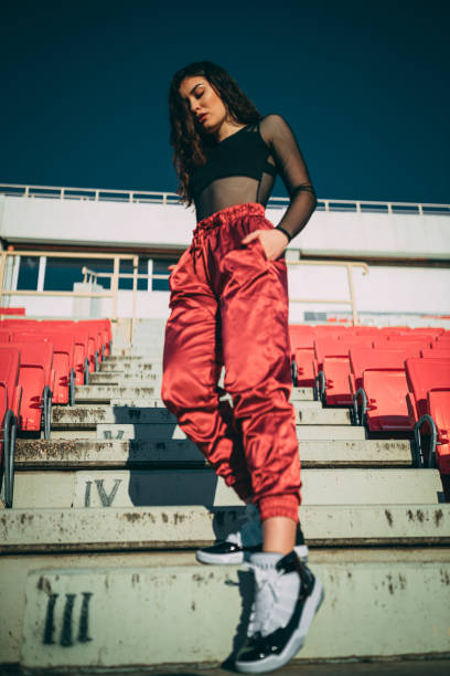 Street styled beautiful woman in an empty sports stadium Portrait of a fashionable street-styled young woman in an empty sports stadium on a sunny day outdoors hipster fashion stock pictures, royalty-free photos & images