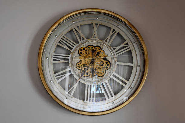Wall clock with Roman Numerals on the wall