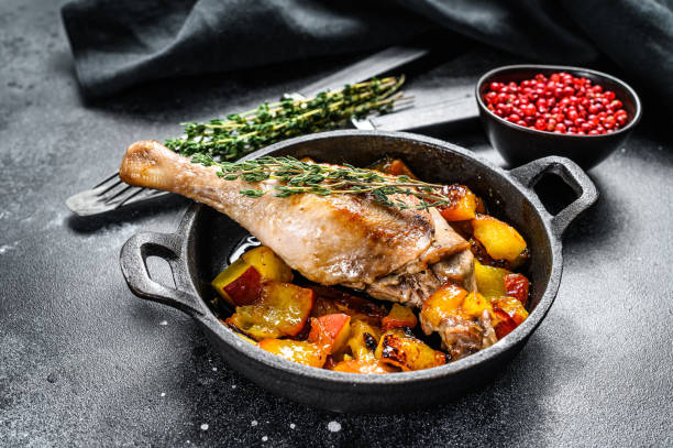 istock Roasted duck legs with oranges, peach and spices.  Black background. Top view 1264628167
