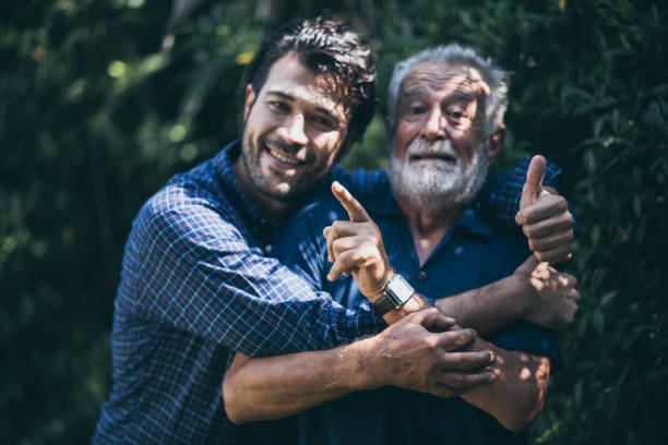 istock Happy Man Embracing Father While Standing By Plant 1264633577