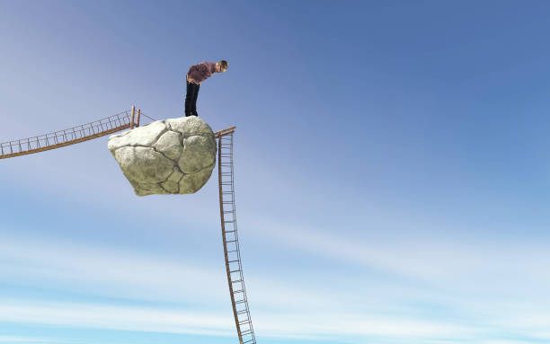 istock Young man looking down to a fallen bridge on a rock . Overcoming obstacle and problems concept . 1264634521