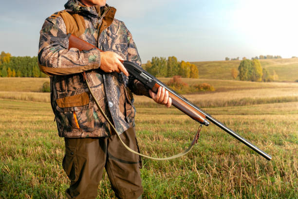 istock Hunting. Hunter in camouflage with a gun hunting. 1264638038