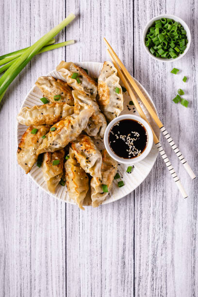 istock Fried dumplings gyoza with soy sauce, and chopsticks, top view 1264639403