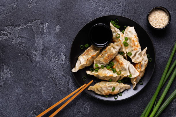 istock Fried dumplings Gyoza on a plate on a gray concrete background 1264640143