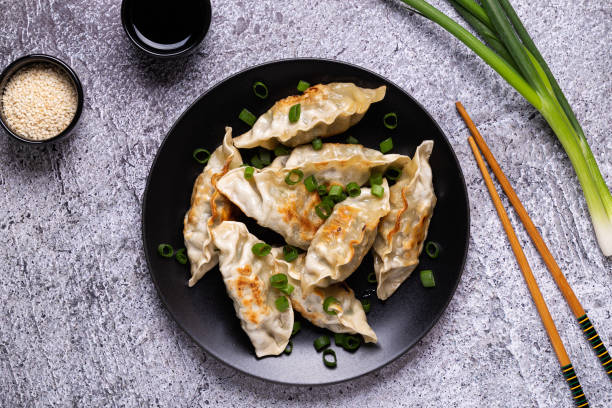 istock Fried dumplings Gyoza on a plate on a gray concrete background 1264640243
