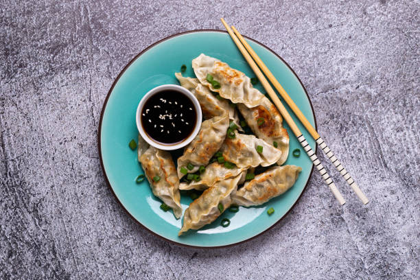 istock Fried dumplings Gyoza on a plate on a gray concrete background 1264640502
