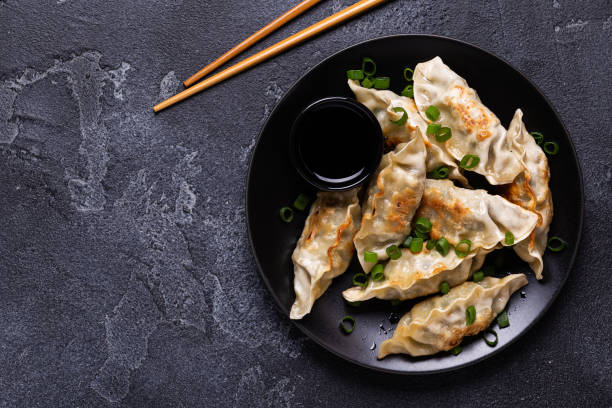 istock Fried dumplings Gyoza on a plate on a gray concrete background 1264640523