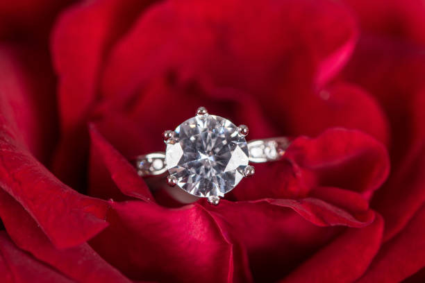 istock Closeup Diamond gem wedding ring on red rose 1264642920