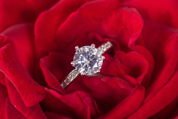 istock Closeup Diamond gem wedding ring on red rose 1264643161