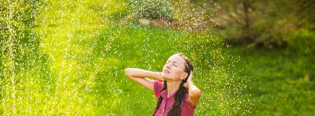 istock Happy young woman having fun under summer rain 1264650664