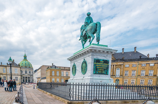 Copenhagen, Denmark - April 28. 2018 - Amalienborg - The large castle square attracts many visitors. view to the Frederiks church Copenhagen,  in the middle the statue of Frederik V.