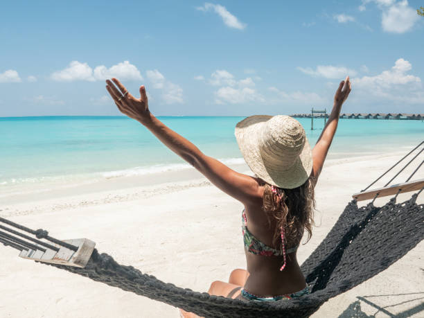 istock Young woman relaxing on hammock arms open embracing life 1264652372