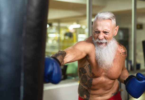 Senior man boxer training hard - Elderly male boxing in sport gym center club - Health fitness and sporty activity concept Senior man boxer training hard - Elderly male boxing in sport gym center club - Health fitness and sporty activity concept old man boxing stock pictures, royalty-free photos & images