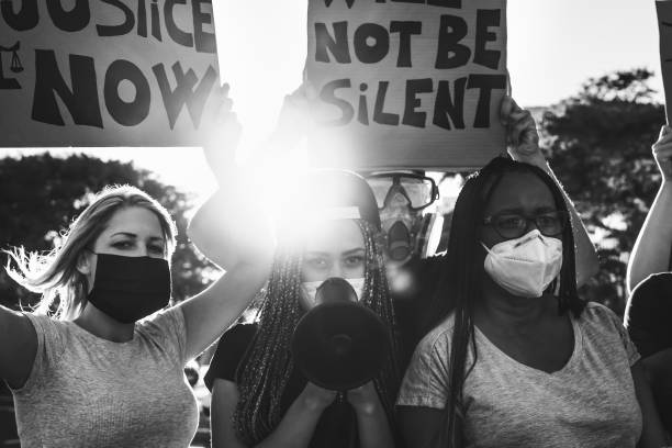 istock protest activist movement protesting against racism and fighting for equality - Demonstrators from different cultures and race protest on street for justice and equal rights 1264654907