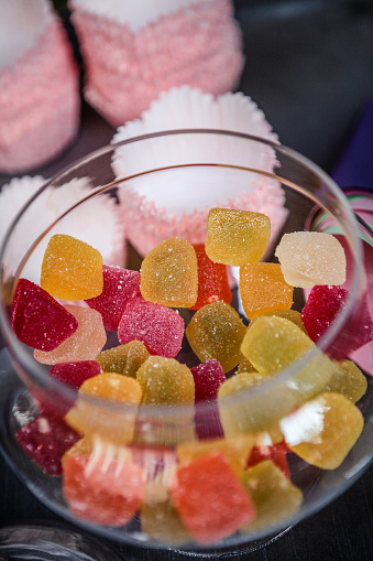Bowl of mixed jelly sweets on mottled grey surface. Flat lay with copy space