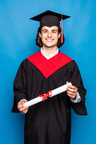 istock Young man with graduation diploma isolated on blue background 1264660483