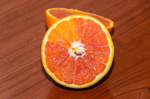 Half orange jucy fruit, close up, wood background.
