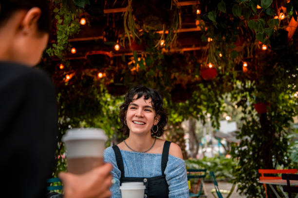 istock Young woman drinking coffee with her friend 1264663968