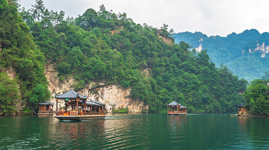 Zhangjiajie, China -  August 2019 : Tourist boats sailing among stunningly beautiful karst landscape surrounding the Baofeng Lake, Wulingyuan, Zhangjiajie National Forest Park, Hunan Province