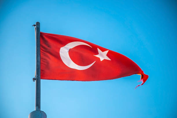 istock The Turkish flag flutters against a clear blue sky 1264668644