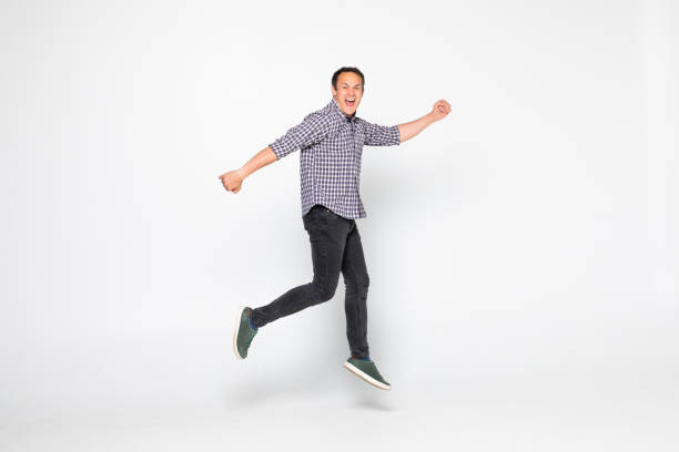 istock Cheerful young man jumping isolated over a white background 1264669883