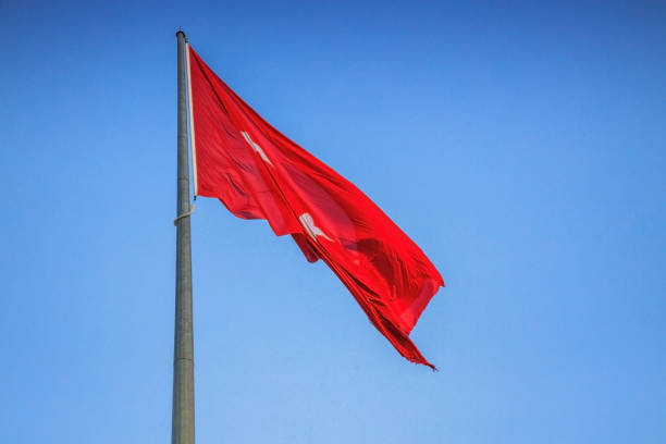 istock The Turkish flag flutters against a clear blue sky 1264669936
