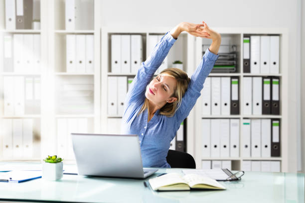 istock Woman Stretches At Office Desk 1264671136