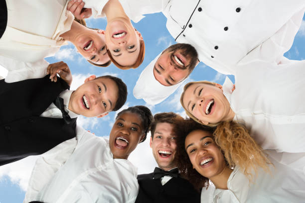 istock Smiling Restaurant Staff Standing Against White Background 1264671179