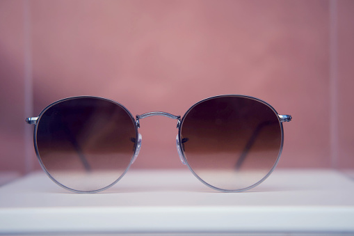 Round sunglasses in silver metal frames close up on a store shelf