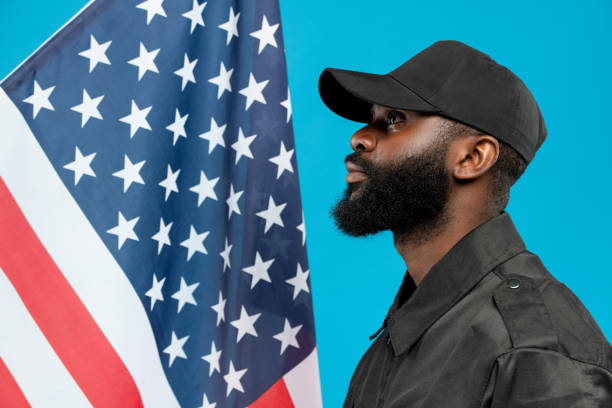 istock Young bearded African-american male security in black uniform and cap 1264675383