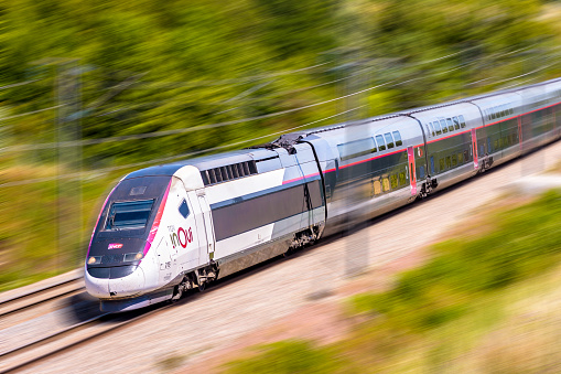 Ver-sur-Launette, France - July 29, 2020: A TGV Duplex inOui high speed train from french rail company SNCF is driving at full speed in the countryside (artist's impression).