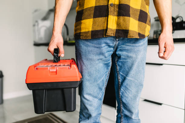istock Close up young man plumber holding toolbox in the kitchen a prepare for work 1264675632