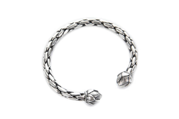 istock Silver bracelet isolated on white background. Round silver bracelet or bangle with lotus flowers carving pattern isolated 1264676603