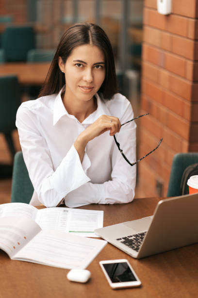 istock Beautiful woman in glasses talking using laptop with smile while sitting and working 1264676657