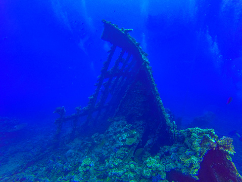 A ship wreck in the Red Sea stands with its half destroyed superstructure  The beautiful hues of blue of the water contrast with the colours of the Red Sea coral reefs. Photos taken off the west coast of Saudi Arabia.