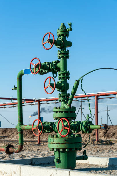 Petroleum well wellhead equipment. Hand valve with handwheel on the flow line. Oilfield site. Oil, gas industry concept. Industrial site background. Production oil. Multiple check valve gate armature. Petroleum well wellhead equipment. Hand valve with handwheel on the flow line. Oilfield site. Industrial site background. Production oil. Multiple check valve gate armature. Oil, gas industry concept. oil wellhead stock pictures, royalty-free photos & images